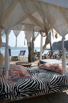 pergola and chairs on beach under palm tree in mexico