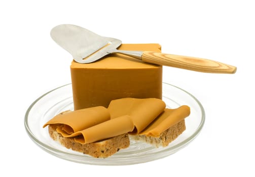 Brown cheese on wholegrain bread and cheesecutter isolated on white.