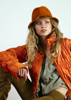 The beautiful young blonde in a red jacket and a hat
