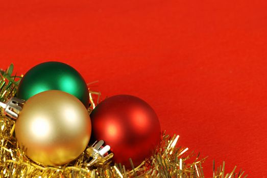 Detail of three christmas balls and chain on a red background frame