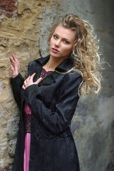Portrait of the young blonde at an old wall