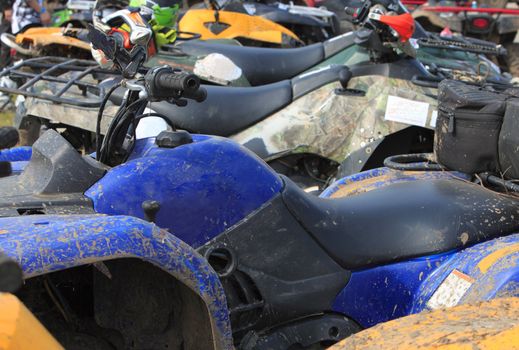 Selective focus on the ATV brake in a crowd of bikes during a muddy race pause. 