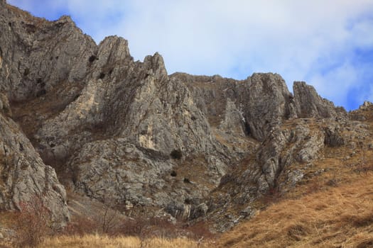 Image of rocks against a cloudy sky in Trascau Mountains,Romania.