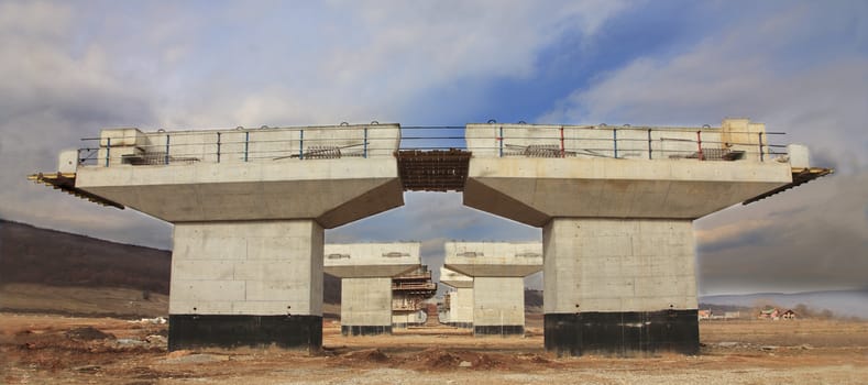 Image of a highway construction site with a beautiful cloudy sky.
