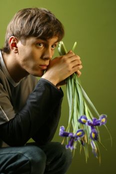 Young the man with a bouquet of irises in hands