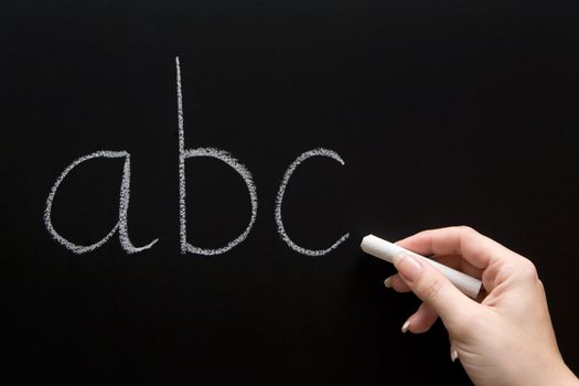 Female teacher writing on a chalkboard.