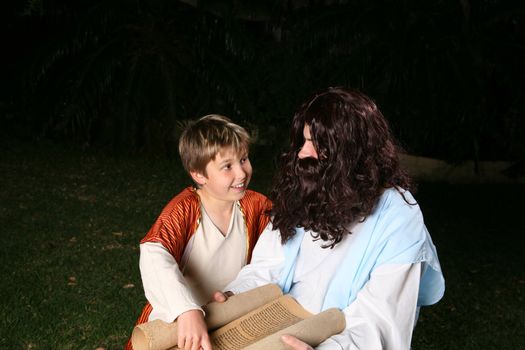A happy child discusses the scriptures with an adult, rabbi or other religious person.