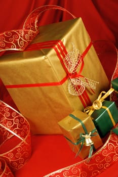 Some Christmas presents with decorations and ribbon over a red background.