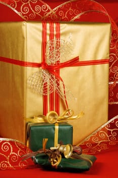 Some Christmas presents with decorations and ribbon over a red background.