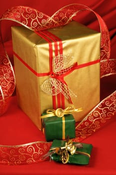 Some Christmas presents with decorations and ribbon over a red background.