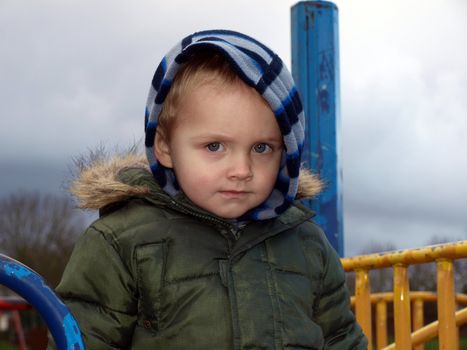 little boy outsite in the cloudy day 