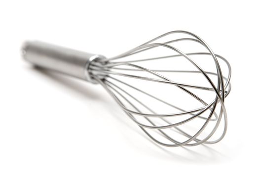 Metal wire whisk. Shallow depth of field. White background.