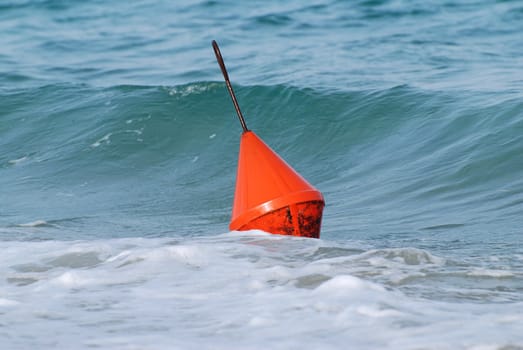 The sea is playing with the orange buoy