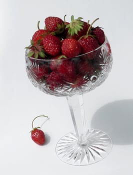 Strawberries in crystal tall wine glass on white