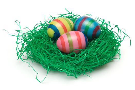 Colorful eggs on artificial grass. Isolated on a white background.