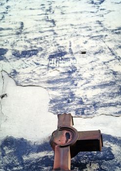 Damaged cross in front of a wall