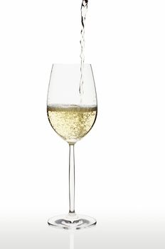 Pouring white wine to isolated wine glass on white bacground