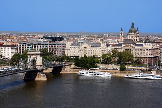 Beautiful view on Hungarian capital city, Budapest. Includes: Danube river, Chain Bridge (Szechenyi), St. Istvan basilica, ships and other buildings.