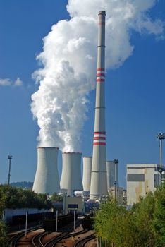 Power plant with supply coal wagons and clouds of white vapour