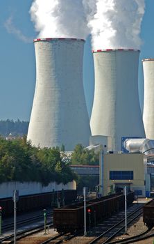 Power plant with supply coal wagons and clouds of white vapour