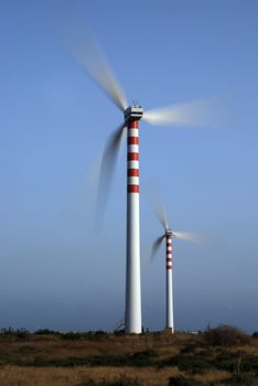 Two wind turbines generating energy - with motion blur