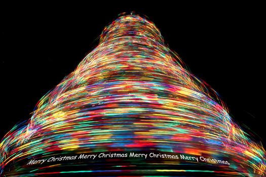 Merry Christmas - Long Exposure of Rotating Christmas Tree with Cycling Optical Fibre Lights against a black background