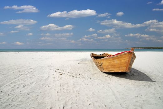 Wooden fishing boat on the white beach