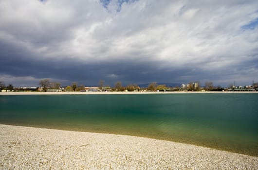 Lake with shore and stormy clouds