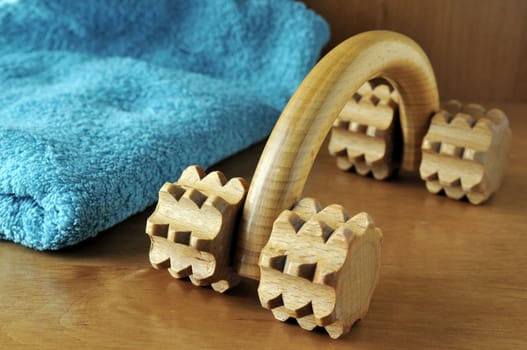 A wooden body massager and a blue towel  