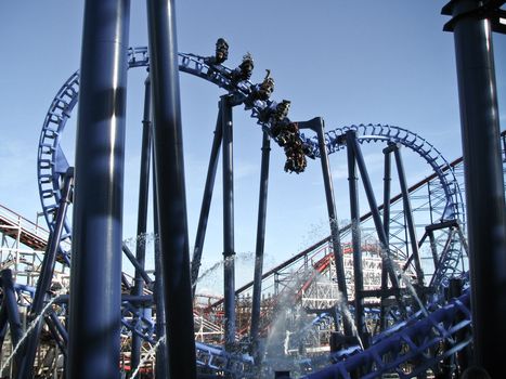 people having fun on roller coaster in amusement park