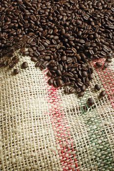 Background image of roasted coffee beans from a canvas sack. Focus across the middle.