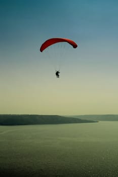 The parachutist in flight over lake