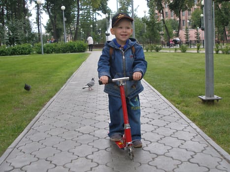 The boy goes for a drive on a skateboard with pleasure