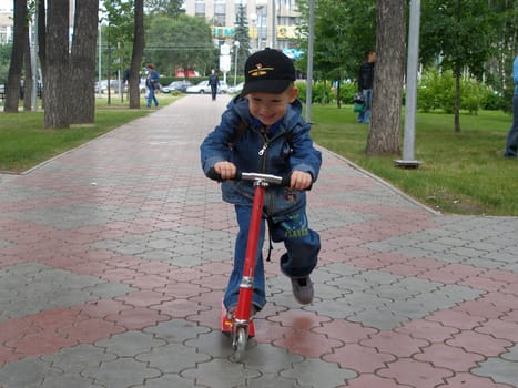 The boy goes for a drive on a skateboard with pleasure    