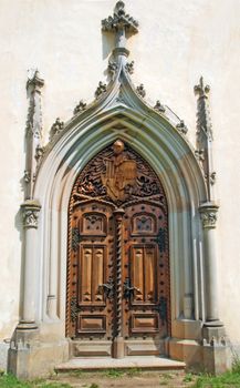 Medieval gothic portal with heraldry carving