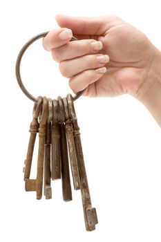Female hand holding a bunch of old keys. Isolated on a white background.