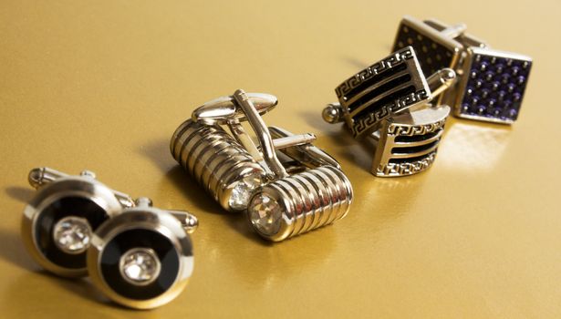 stainless steel cufflinks on the gold background