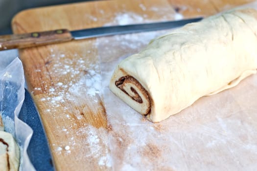 Uncooked cinnamon rolls dough with knife