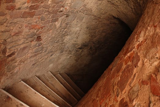 Ancient stairway in abandoned ruined castle tower leading to catacoms