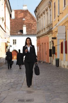 Businesswoman checking her mobile while walking.