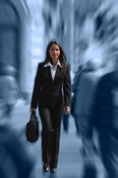 Businesswoman walking quickly in a crowded downtown.The image presents a significant spin blur effect to accentuate the dynamism of the scene.