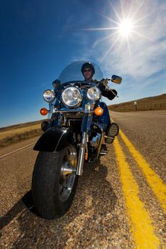 A biker enjoying a ride in the country side on a sunny day