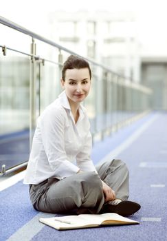 Businesswoman is sitting on the floor with a calendar beside her