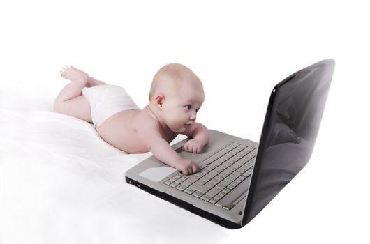  baby on a white sheet playing with a laptop