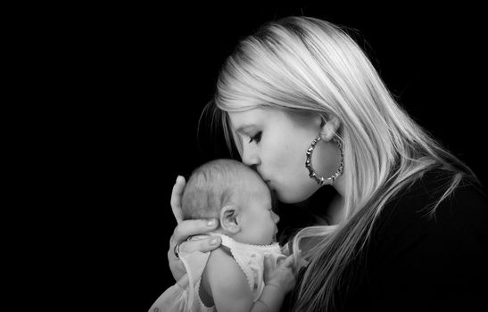 Young mother kissing her newborn baby