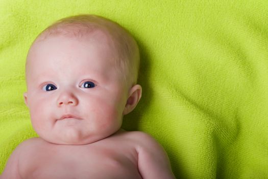 Newborn baby on a green towel