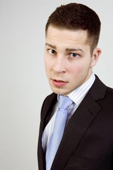 Portrait of young man in business clothes looking agressively at camera