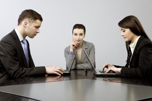 Business group portrait - Young man and two women working together on laptops