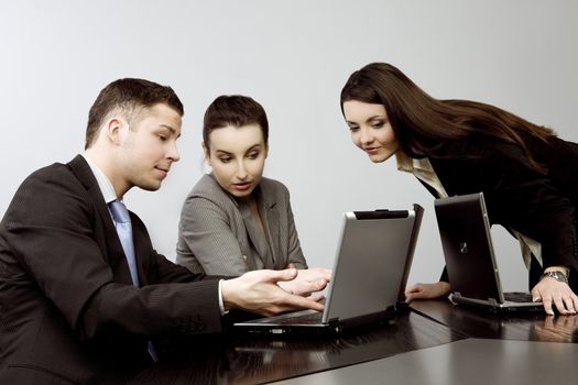 Business group portrait - Young man and two women working together on laptops