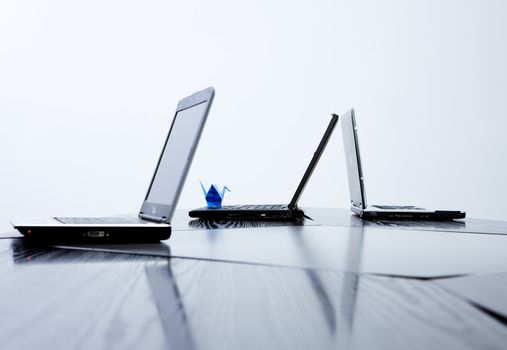 Composition of three notebooks with blue origami animal on one of them